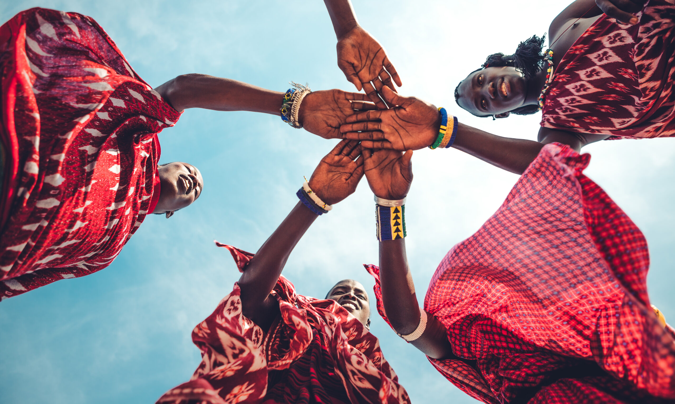 post 1 Masai in traditional clothes joining hands in unity (Zanzibar, Tanzania).